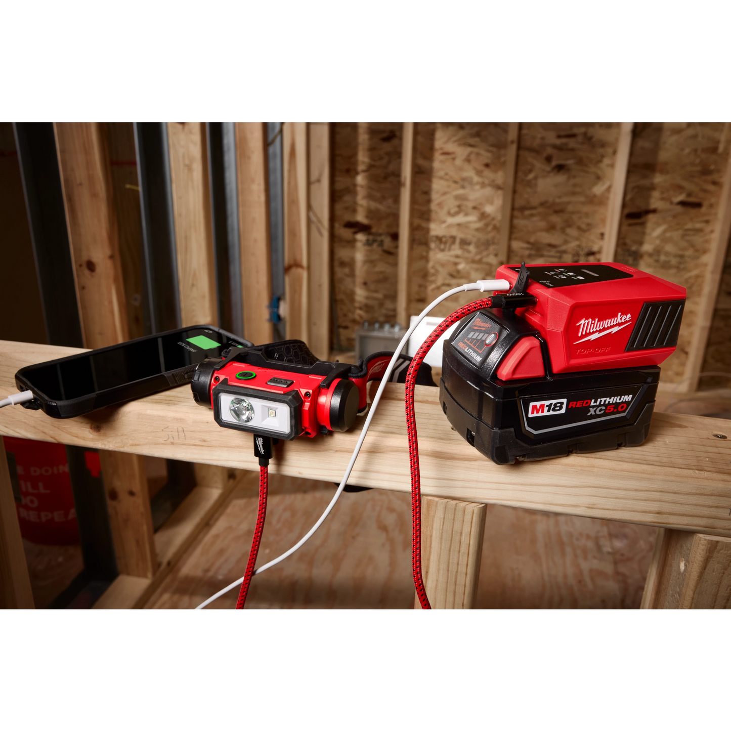 Milwaukee M18 TOP-OFF charging a headlamp on a jobsite