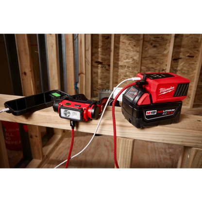 Milwaukee M18 TOP-OFF charging a headlamp on a jobsite